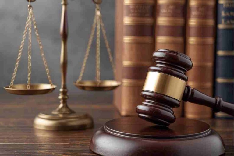 Scales of justice and a gavel with law books in the background.